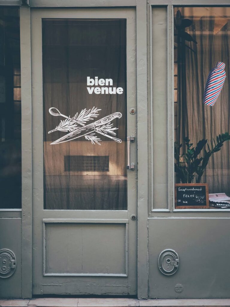 closed shop in Paris with the words “bienvenue” in door