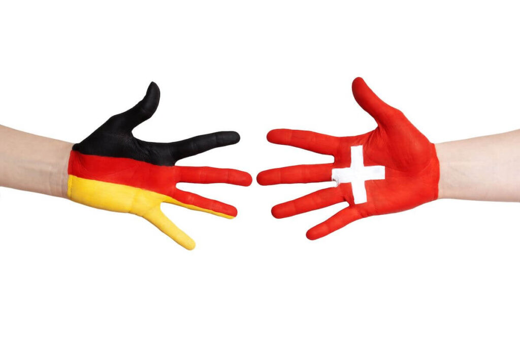 two painted hands with Swiss and German flag symbols