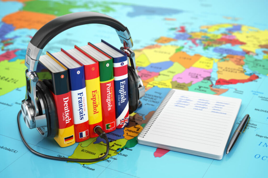 language books and headphones on top of a world map
