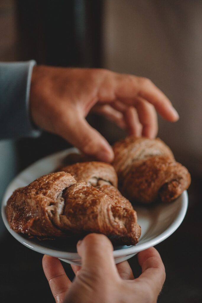 man helping himself to croissants