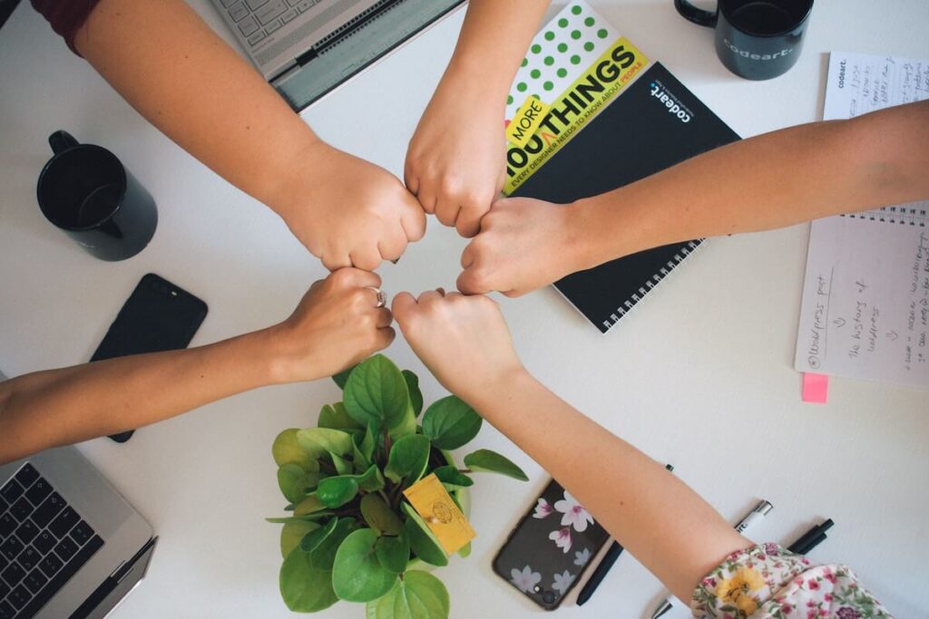 Various fists in a circle, demonstrating teamwork