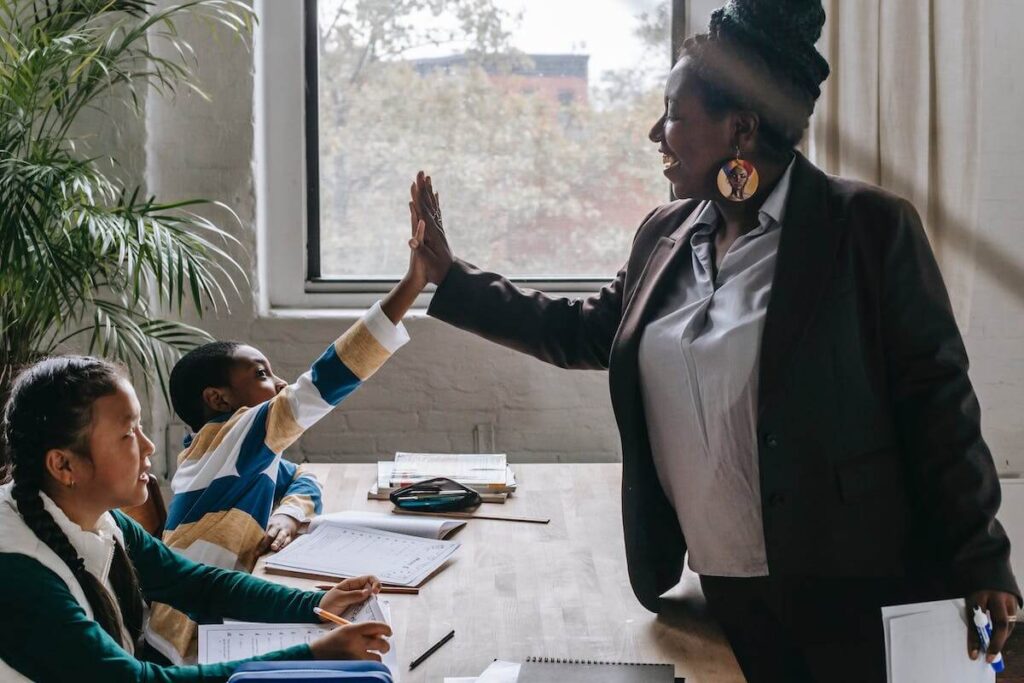 Woman high fives child sitting at table