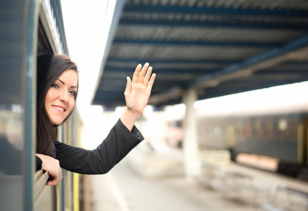 Young woman traveling by train, saying goodbye