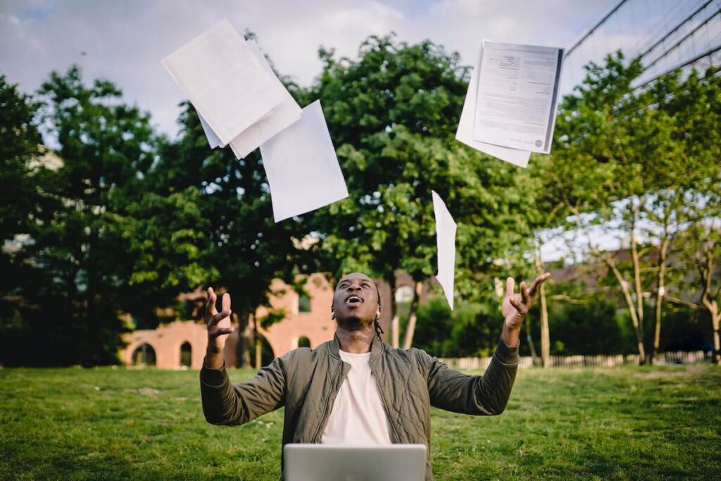 man throws papers in the air