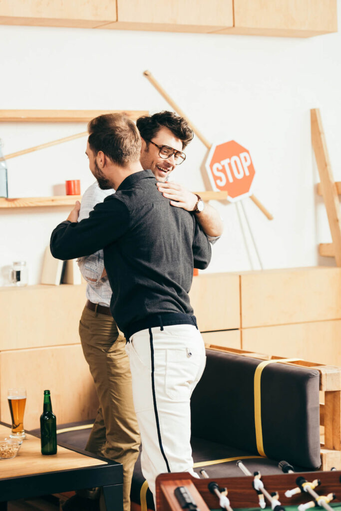 Young friends greeting each other in cafe