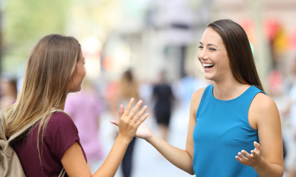 Two happy friends meeting on the street