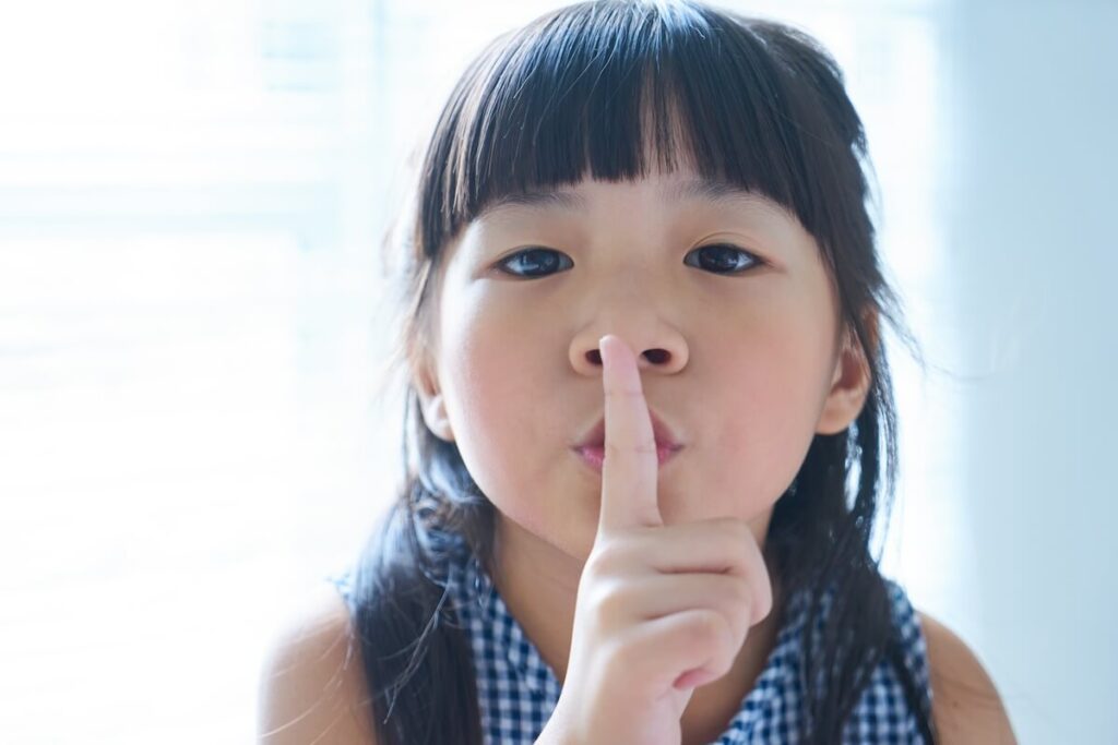 Girl holding her finger to her lips
