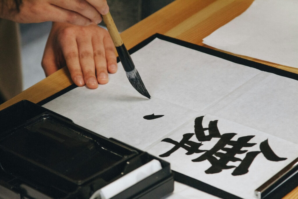 Person writing kanji calligraphy