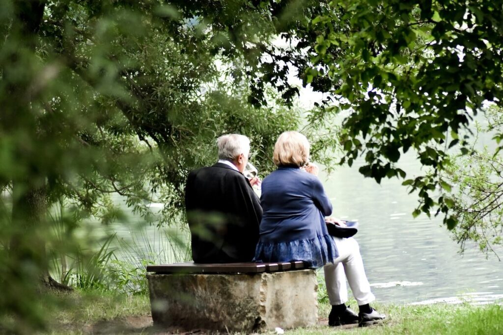 old couple on a date in park by the lake