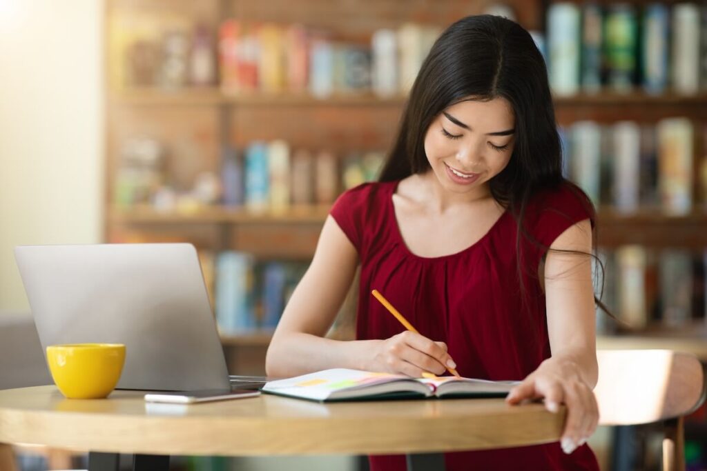 woman studying and answering a workbook