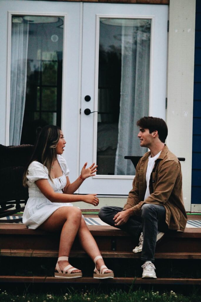 man and woman talking on porch