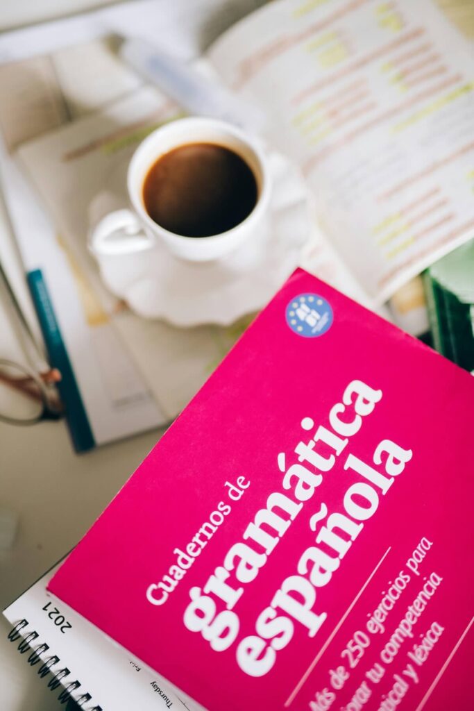 Spanish grammar book and cup of coffee on top desk