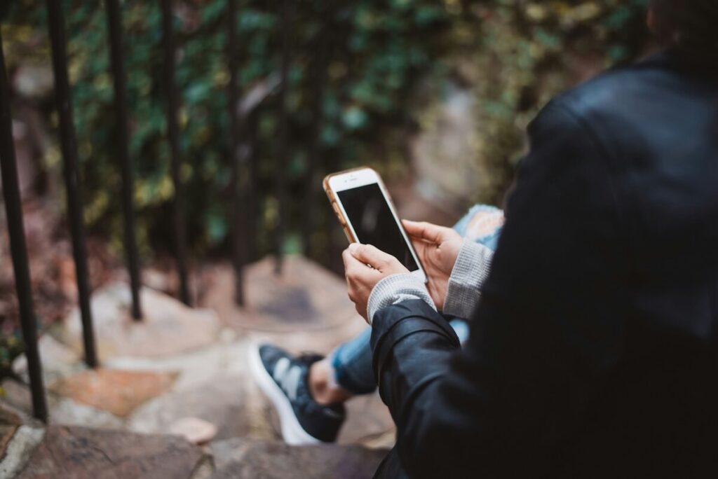 person sitting in stair and using mobile phone