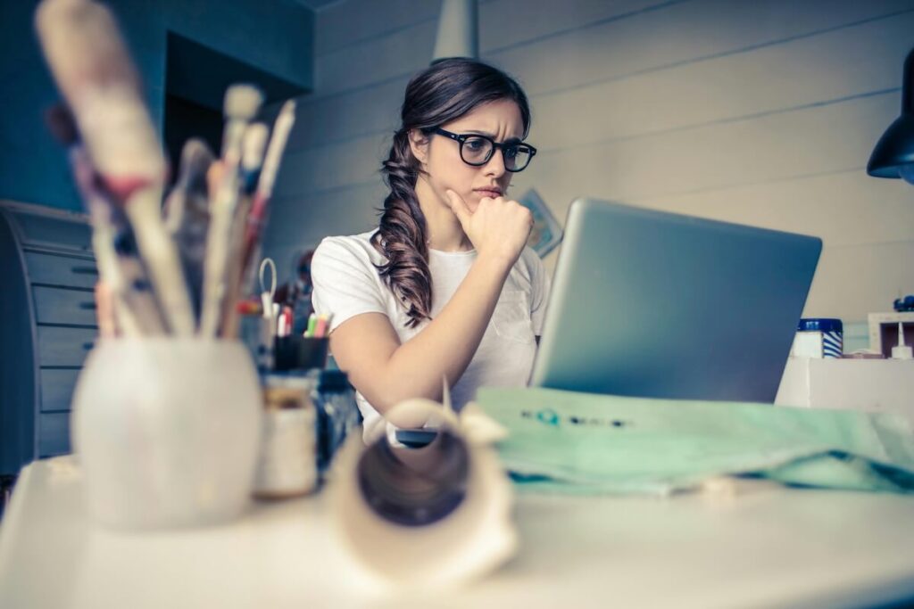 woman thinking while using laptop