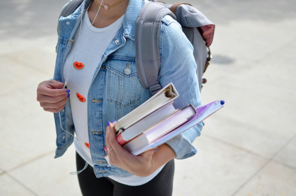 student carrying bag and school books
