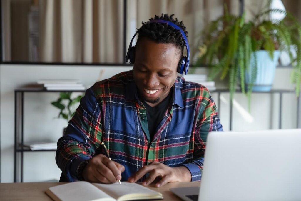 man smiling while studying with laptop