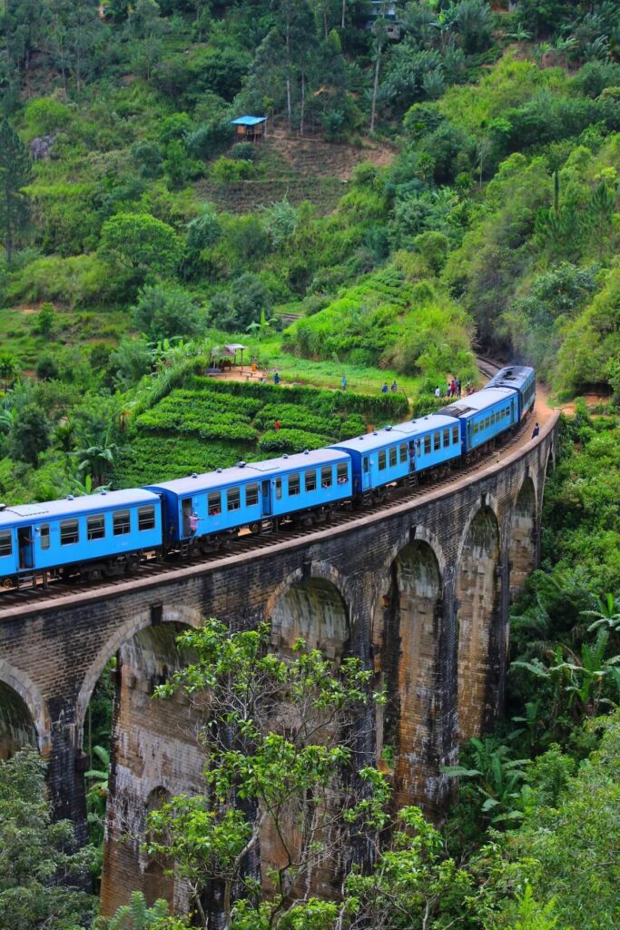 blue train passing over Nine Arch Bridge in Sri Lanka