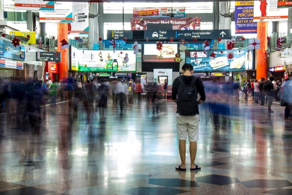 person standing amidst timelapse inside a transportation hub in Kuala Lumpur, Malaysia