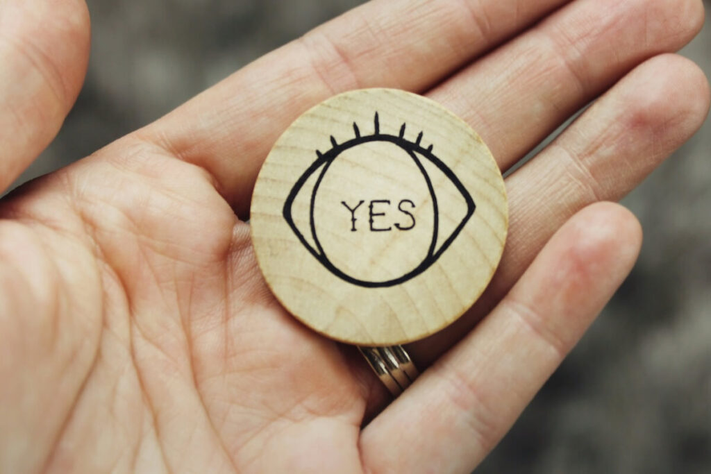 hand holding a buttton that says "yes"