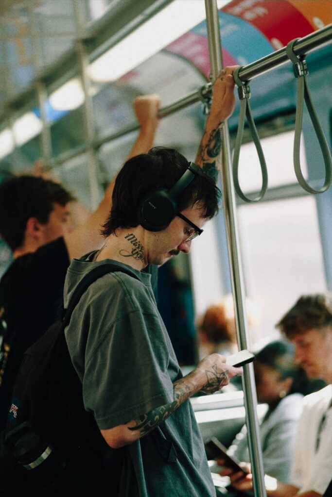 man listening with headphones inside train