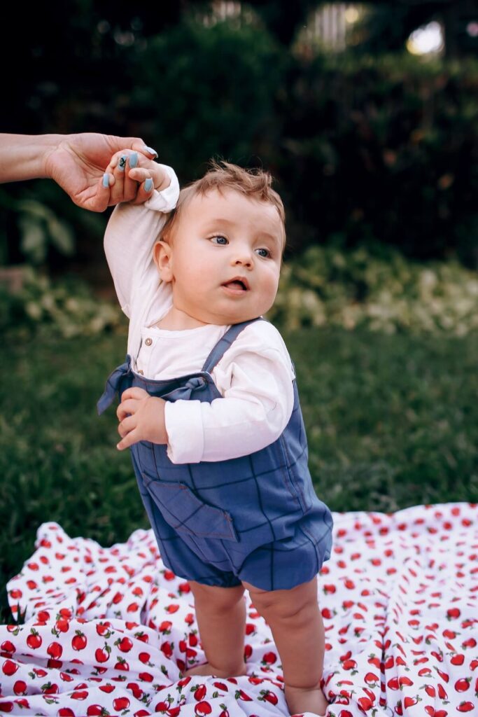 baby standing up on picnic mat
