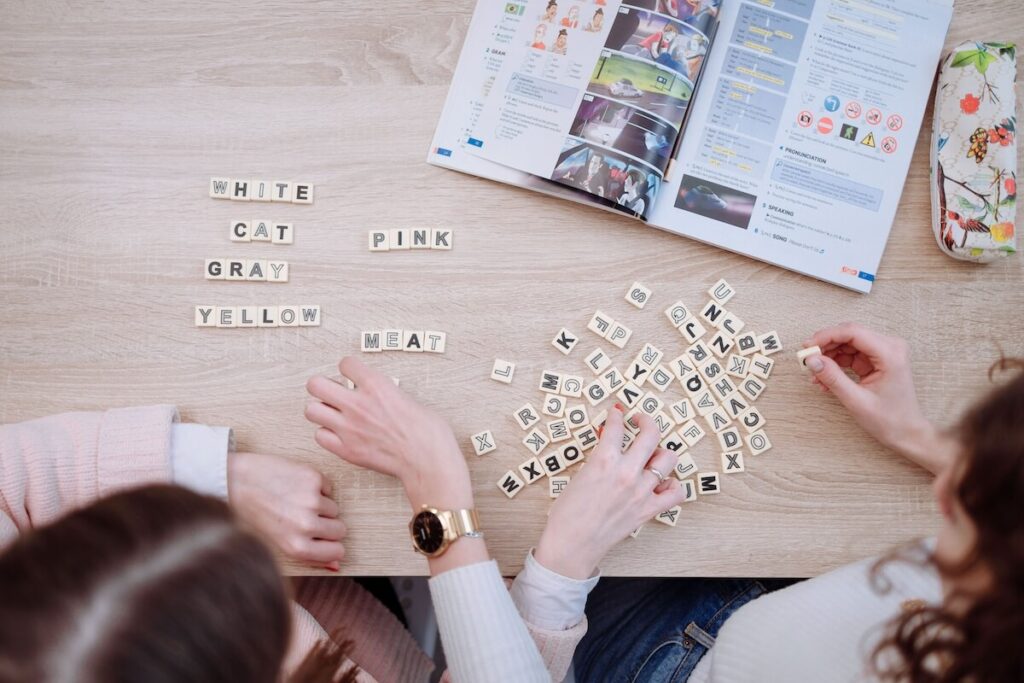 learning English with a book and letter tiles