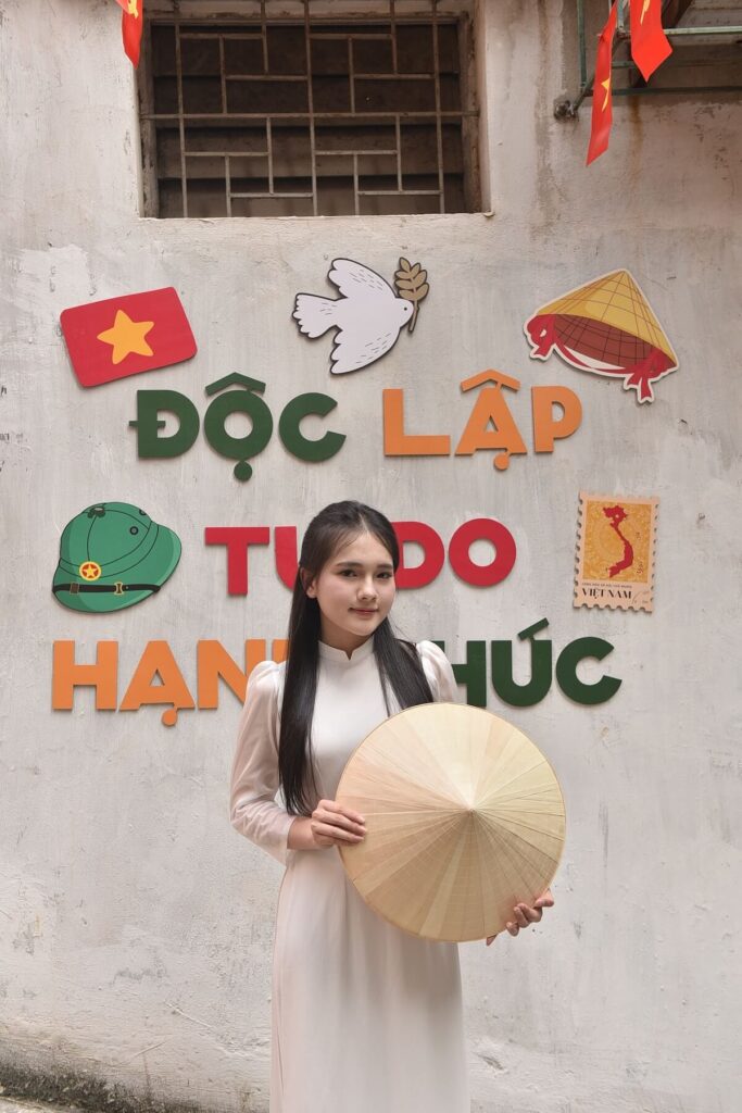 Vietnamese woman posing in front of wall art
